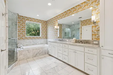 a spacious bathroom with a tub sink and mirror