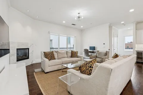 a living room with lots of white furniture and a chandelier