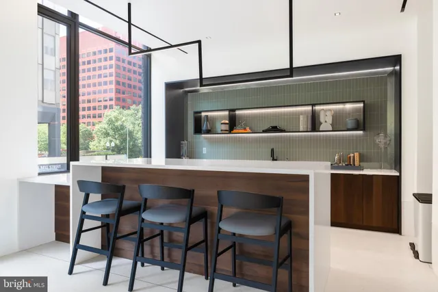 a view of a elevator with a potted plant on a table and a painting on the wall