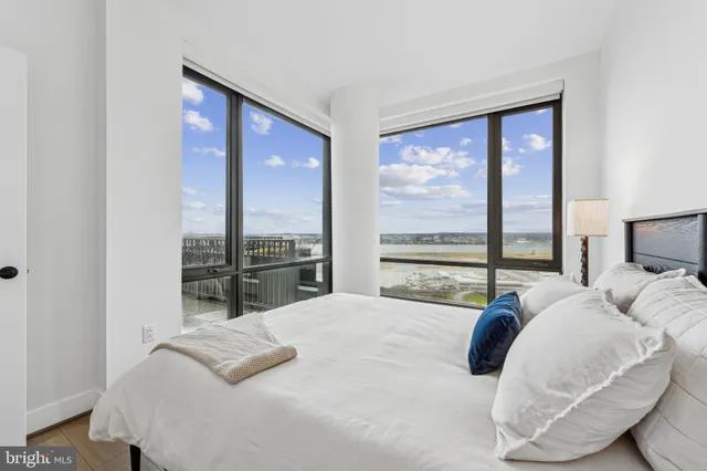 a bedroom with a bed and large windows