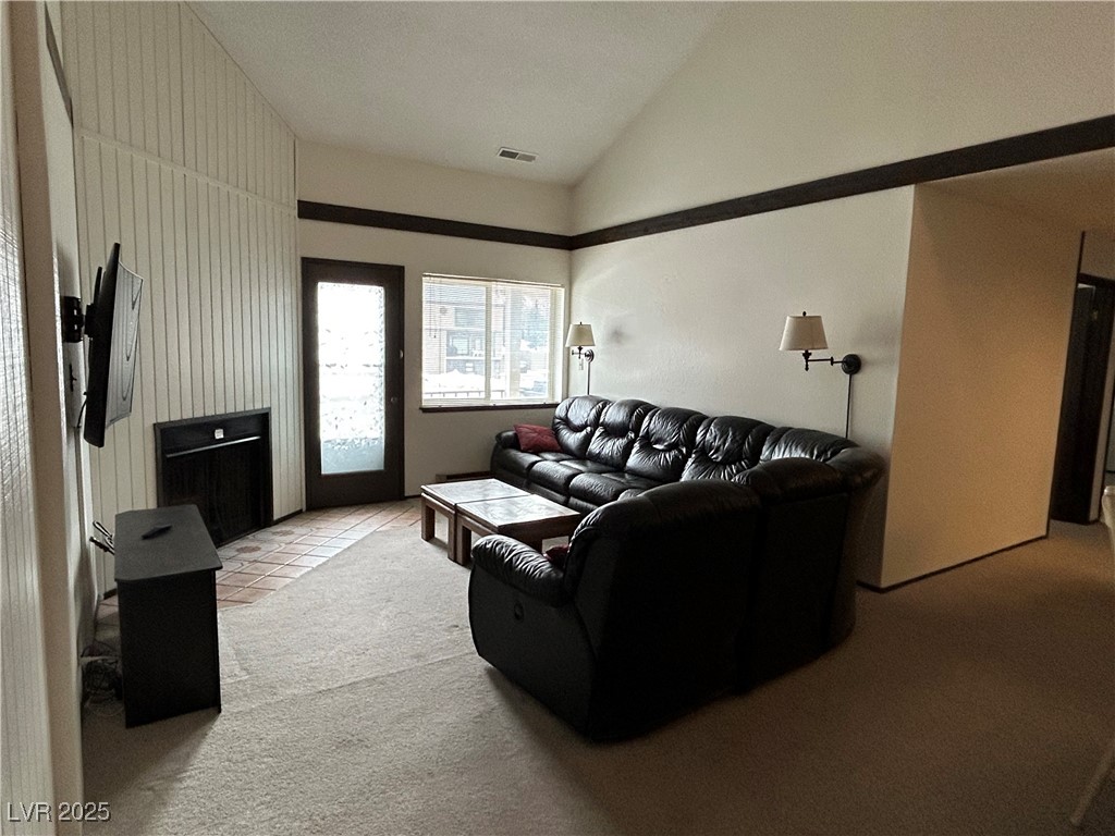 Living room featuring lofted ceiling, light tile p