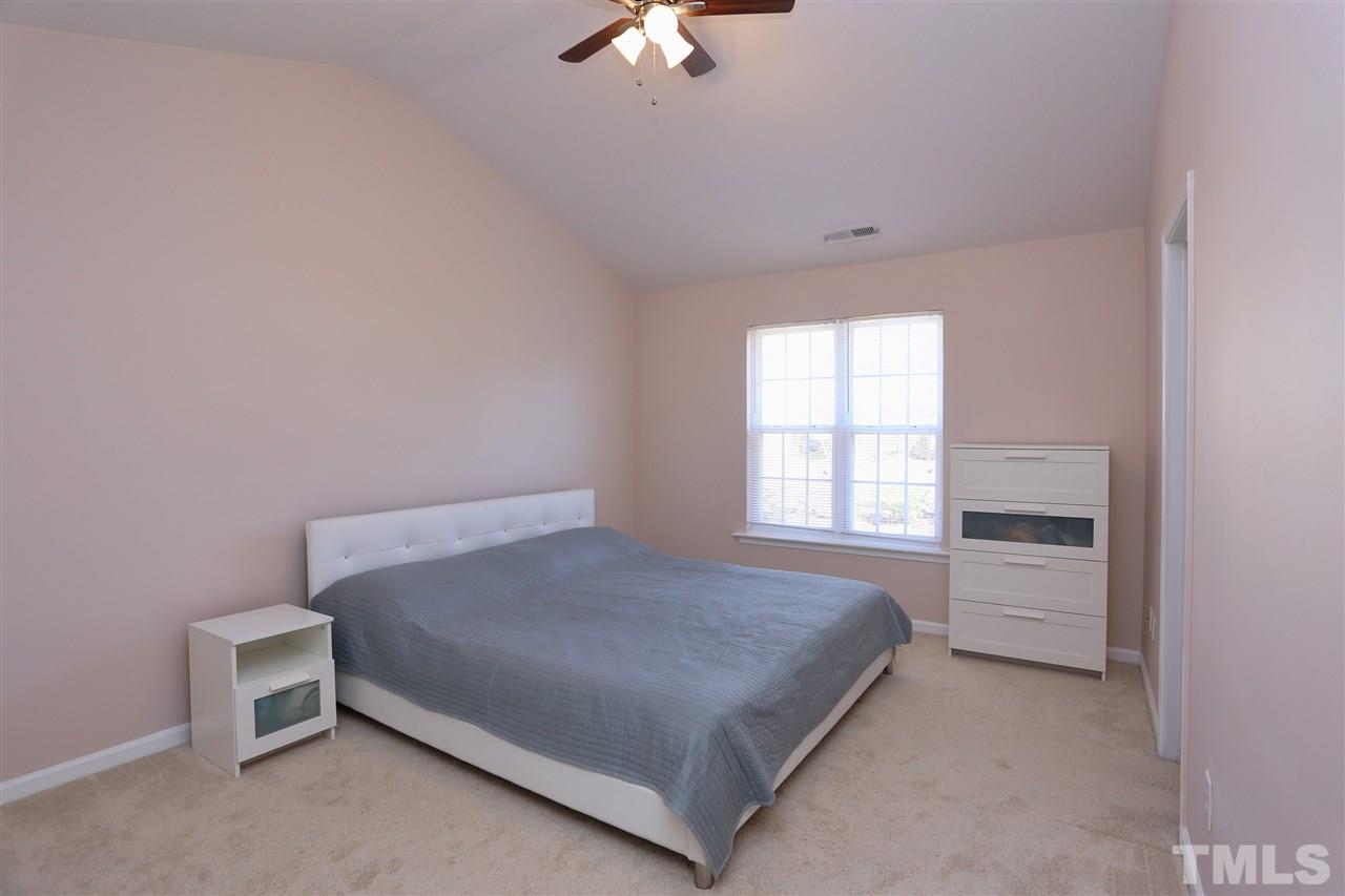 2134 Metacomet Way Raleigh, NC 27604 - Photo 13 of 25 a bedroom with a bed and a chandelier fan