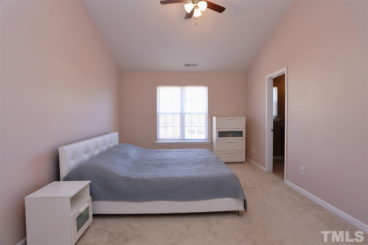 2134 Metacomet Way Raleigh, NC 27604 - Photo 14 of 25 a bedroom with a bed and a chandelier