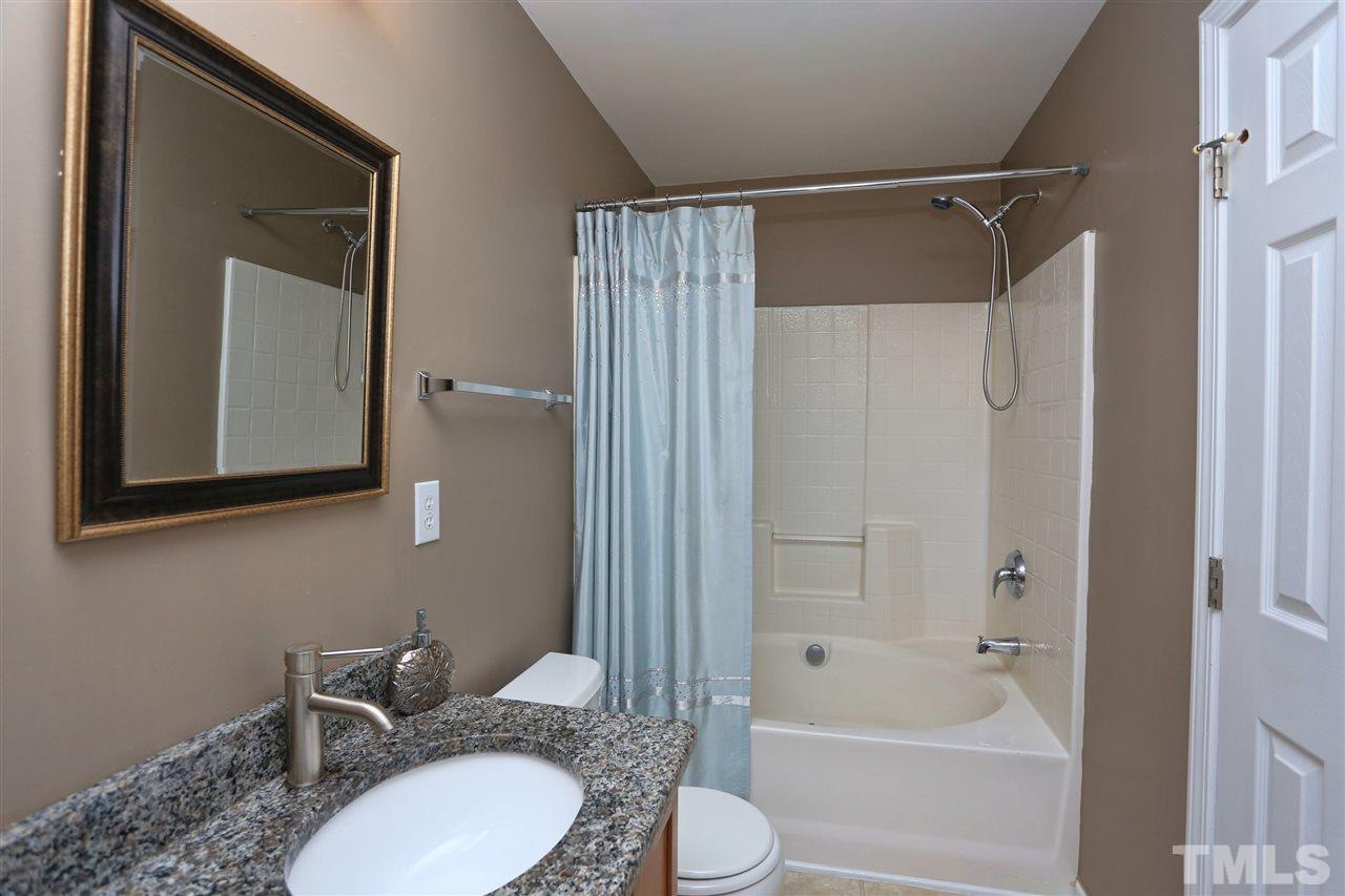 2134 Metacomet Way Raleigh, NC 27604 - Photo 16 of 25 a bathroom with a granite countertop sink toilet a shower and a mirror