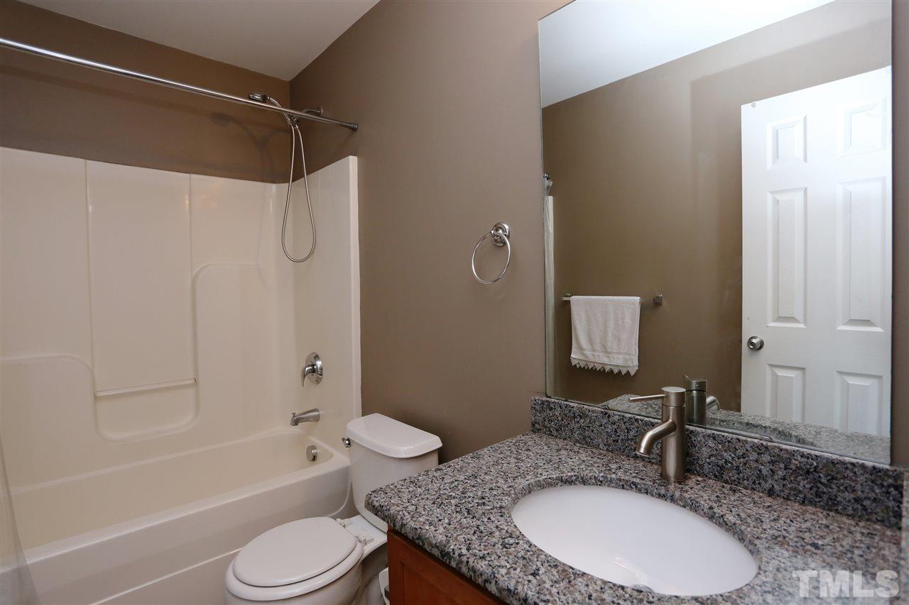 2134 Metacomet Way Raleigh, NC 27604 - Photo 18 of 25 a bathroom with a granite countertop sink toilet a mirror and shower