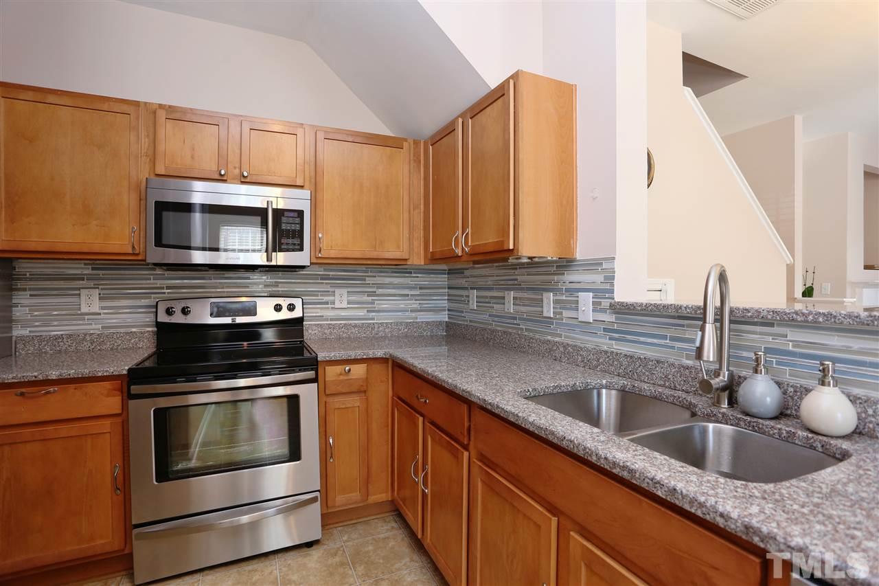 2134 Metacomet Way Raleigh, NC 27604 - Photo 5 of 25 a kitchen with granite countertop a sink a stove and microwave