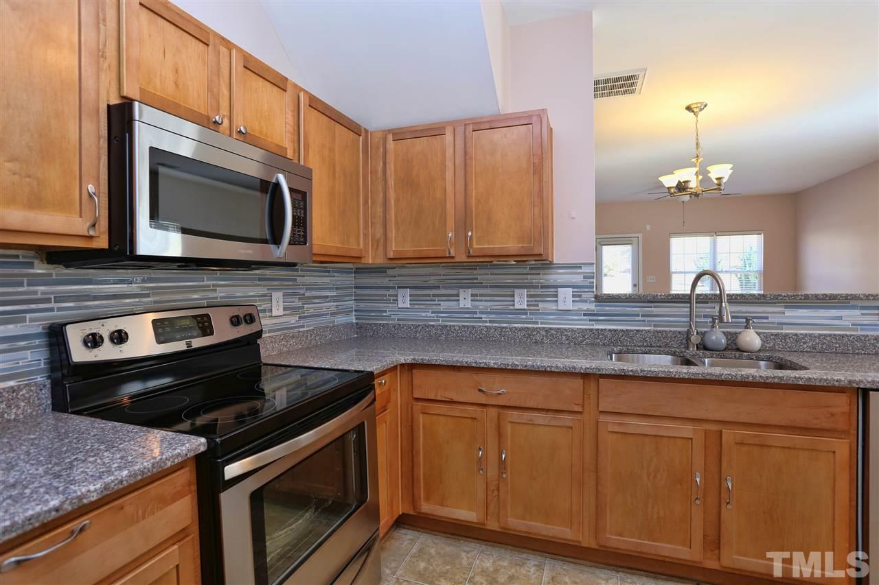 2134 Metacomet Way Raleigh, NC 27604 - Photo 7 of 25 a kitchen with granite countertop a stove sink and microwave