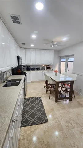 a kitchen with a dining table chairs stainless steel appliances and cabinets