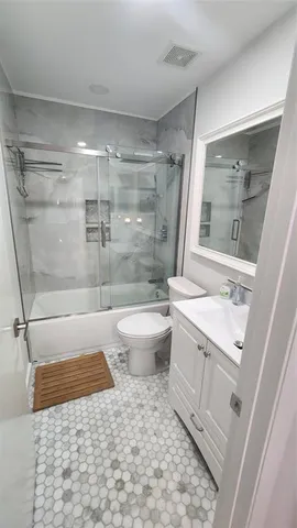a bathroom with a granite countertop sink toilet and shower