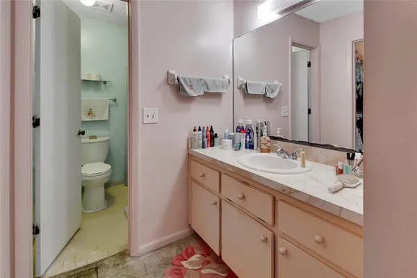 a bathroom with a granite countertop sink a toilet and a mirror