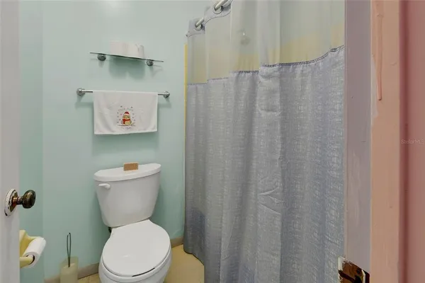 a white toilet sitting next to a shower curtain