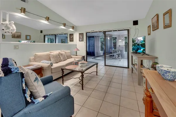 a living room with furniture and a dining table with kitchen view