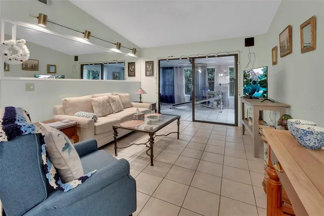 a living room with furniture and a dining table with kitchen view