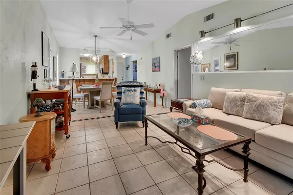 a living room with furniture and a dining table with kitchen appliances