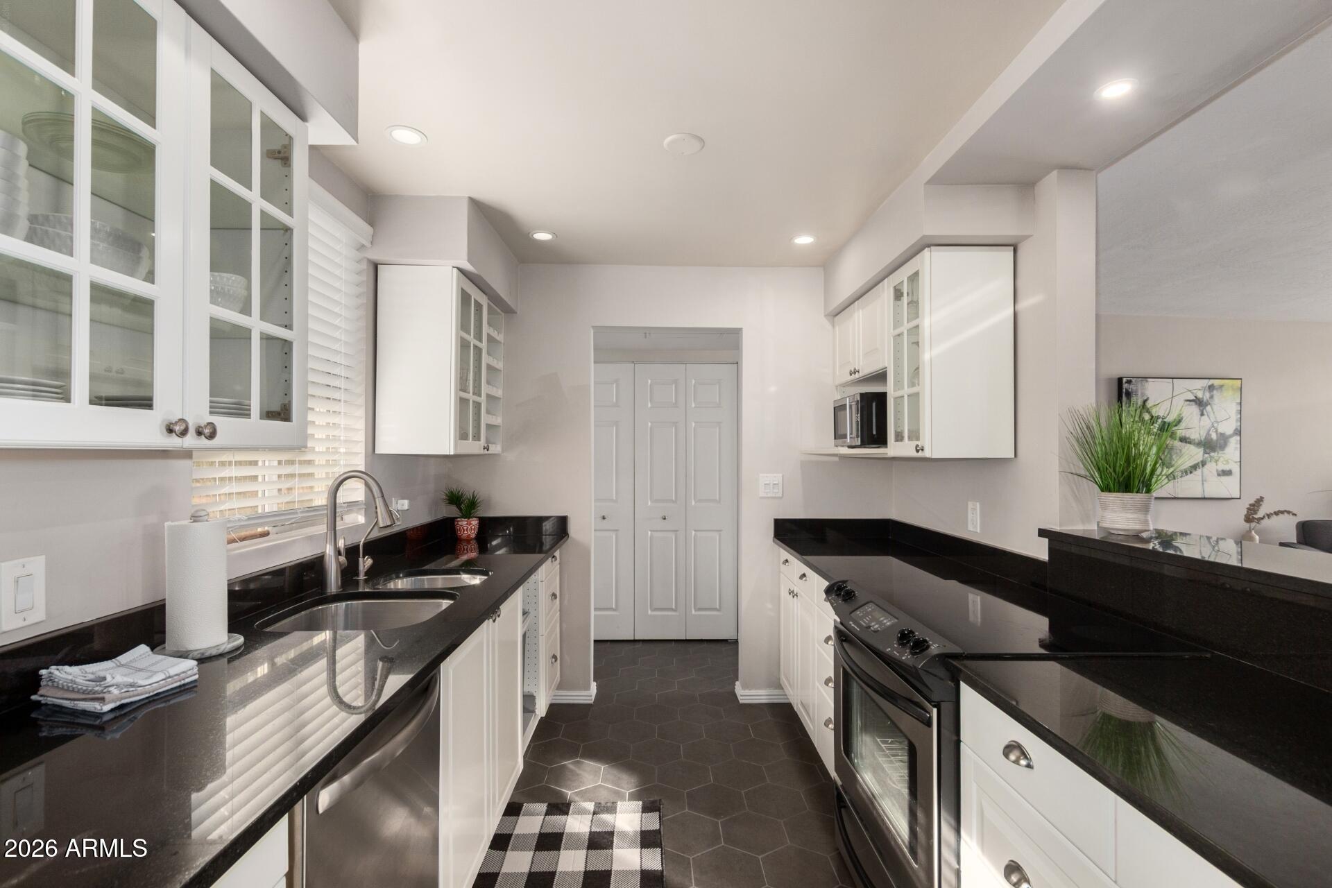 3270 East Camelback Road, Unit 213 Phoenix, AZ 85018 - Photo 11 of 41 a kitchen with a sink stove top oven and cabinets
