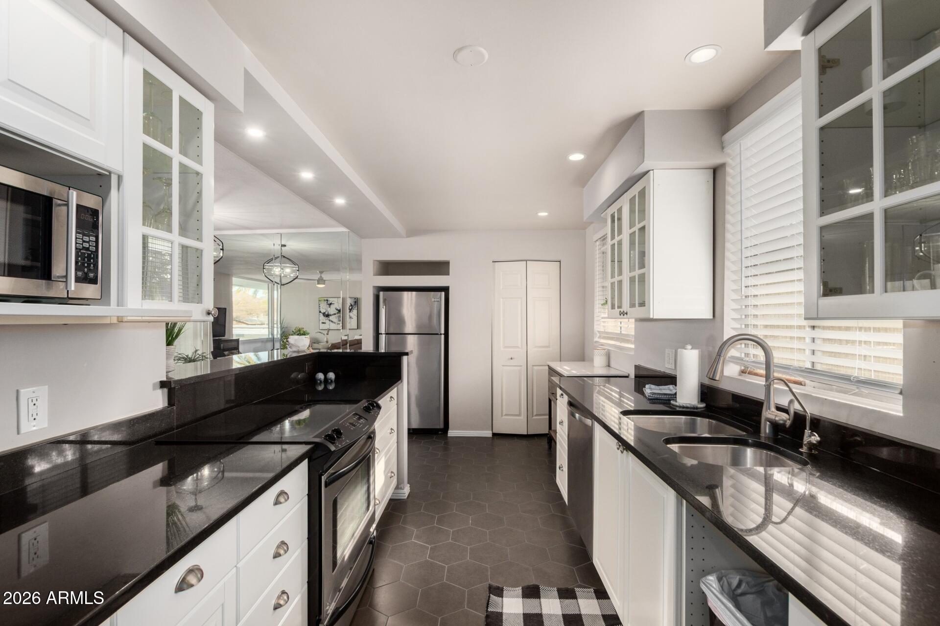 3270 East Camelback Road, Unit 213 Phoenix, AZ 85018 - Photo 12 of 41 a kitchen with granite countertop a sink a stove and refrigerator
