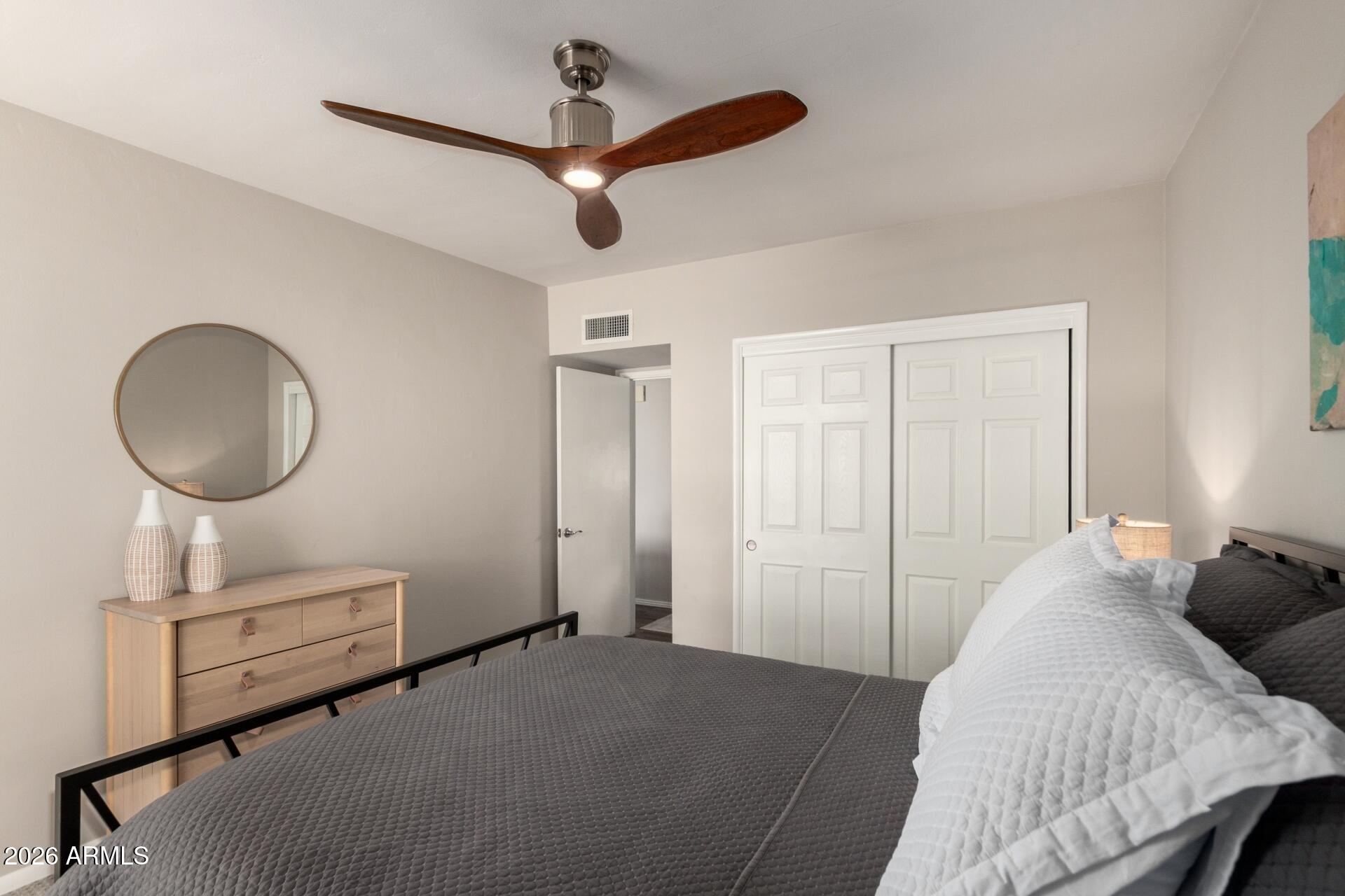 3270 East Camelback Road, Unit 213 Phoenix, AZ 85018 - Photo 21 of 41 a bedroom with a bed and a chandelier