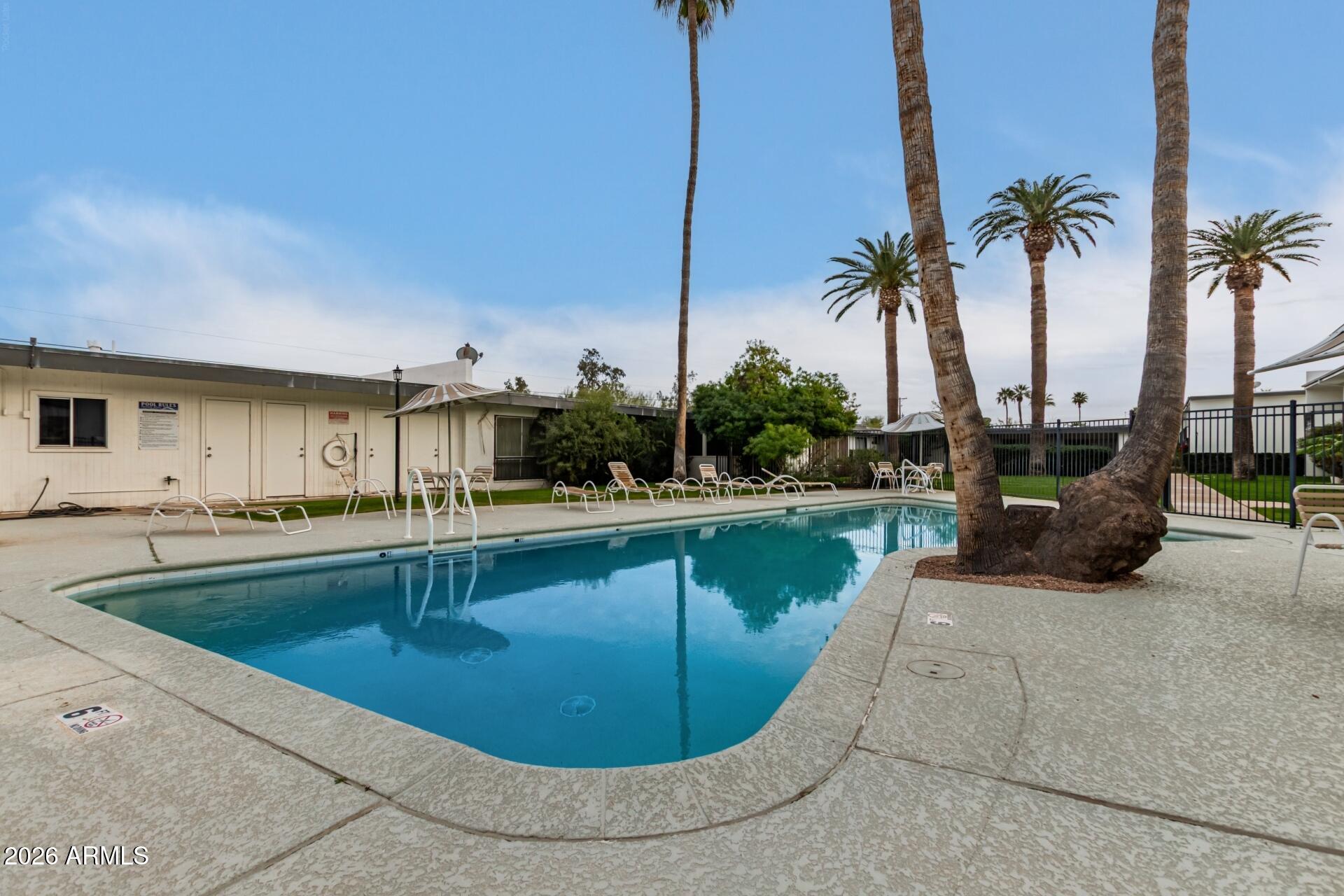 3270 East Camelback Road, Unit 213 Phoenix, AZ 85018 - Photo 32 of 41 a view of a swimming pool with a lounge chair