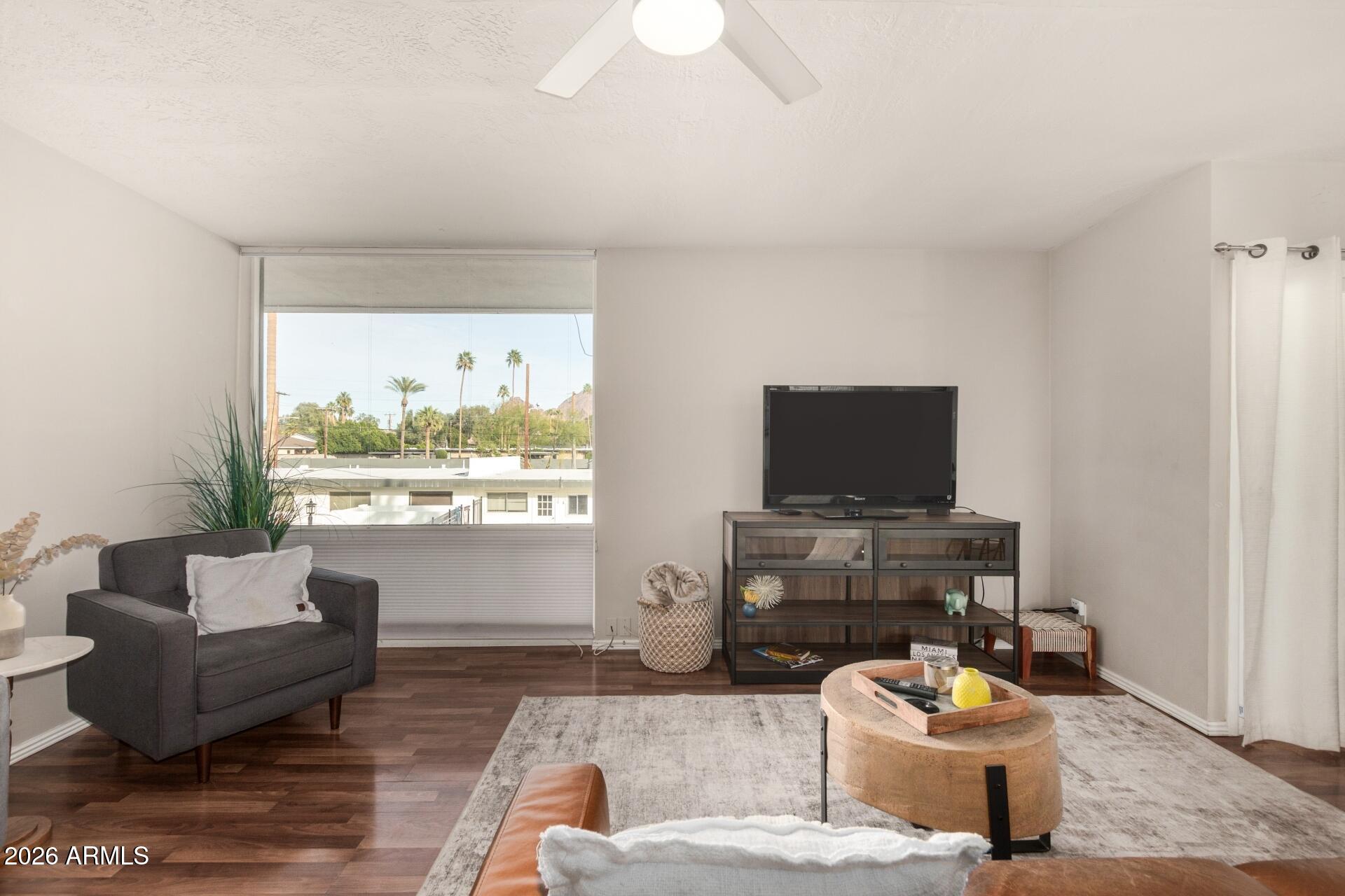 3270 East Camelback Road, Unit 213 Phoenix, AZ 85018 - Photo 6 of 41 a living room with furniture a flat screen tv and a large window