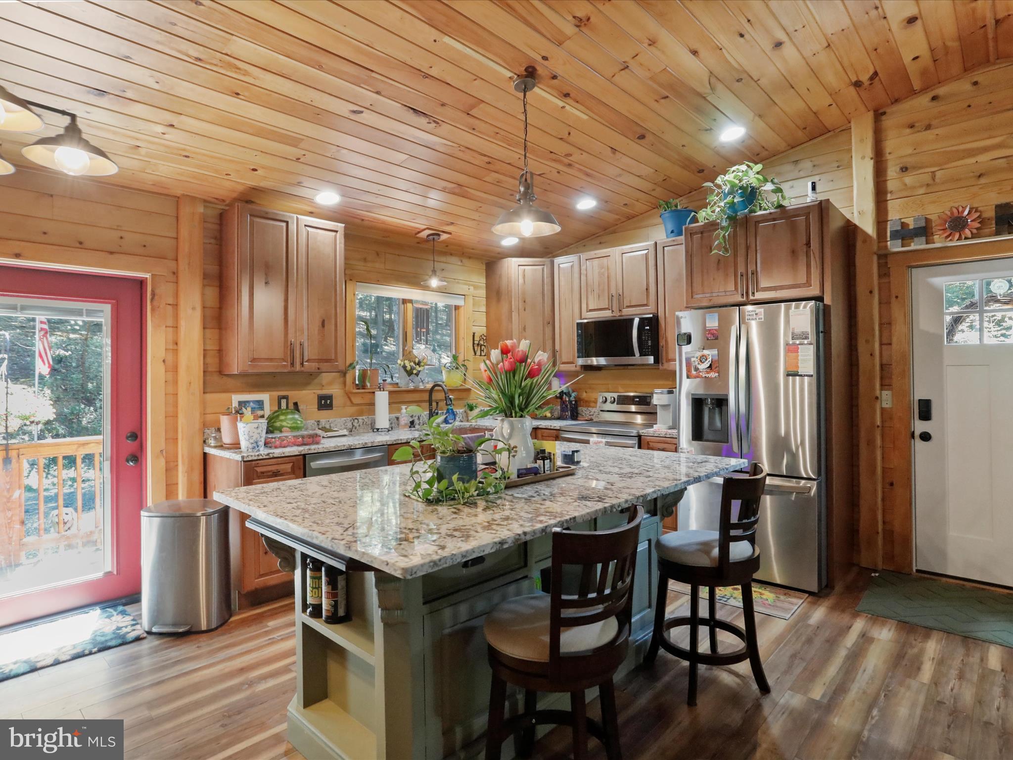 480 High Mountain Road Romney, WV 26757 - Photo 22 of 46 a kitchen with stainless steel appliances granite countertop a table chairs sink refrigerator and microwave