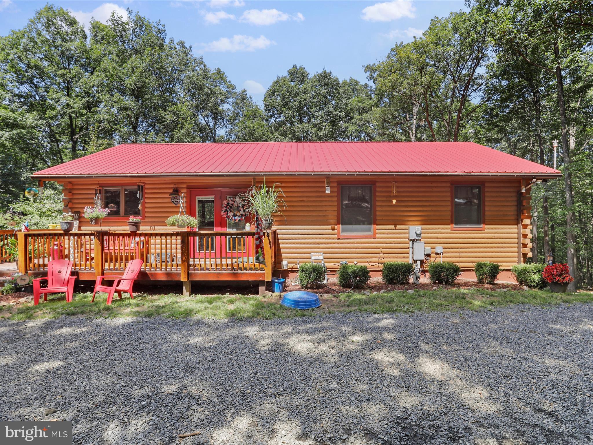 480 High Mountain Road Romney, WV 26757 - Photo 3 of 46 a view of a house with a yard and lawn chairs under an umbrella