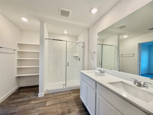 a bathroom with a double vanity sink mirror and shower