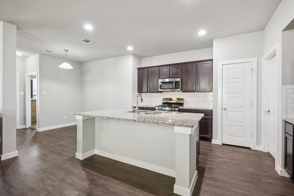 5112 Cathy Drive Forney, TX 75126 - Photo 6 of 32 a kitchen with stainless steel appliances granite countertop a sink stove and refrigerator