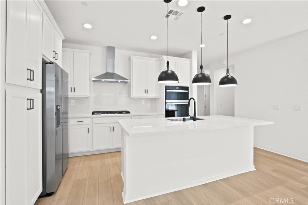 383 Moonflower Rancho Mission Rancho Mission Viejo, CA 92694 - Photo 1 of 1 a kitchen with stainless steel appliances kitchen island a refrigerator and a wooden floors
