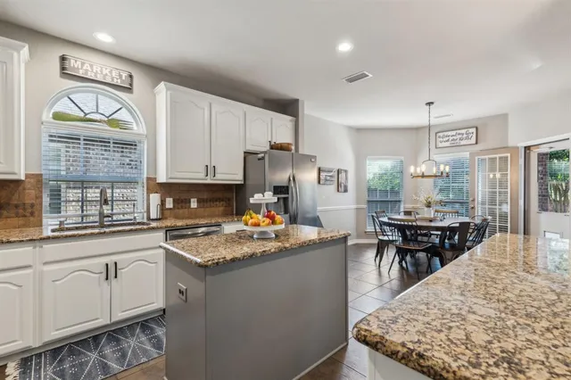 a kitchen with stainless steel appliances granite countertop a stove top oven a sink dishwasher and cabinets with wooden floor