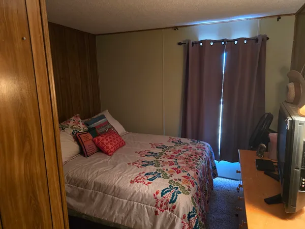 a bedroom with a bed a mirror and a closet