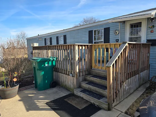 a view of a house with a small yard and wooden fence
