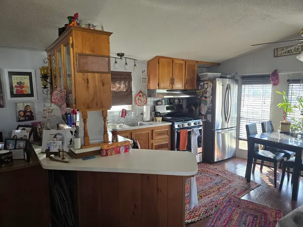 a kitchen with kitchen island granite countertop a sink counter top space and appliances