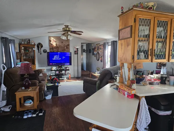 a living room with furniture a flat screen tv and a window