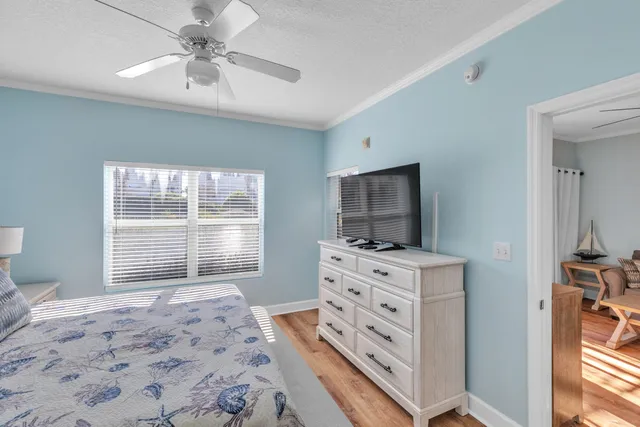a bedroom with a bed and a flat tv screen on dresser