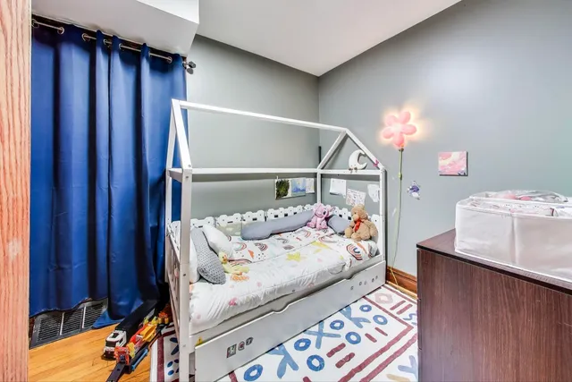 a bedroom with a bed and wooden floor