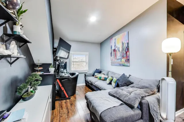 a living room with furniture kitchen view and a flat screen tv