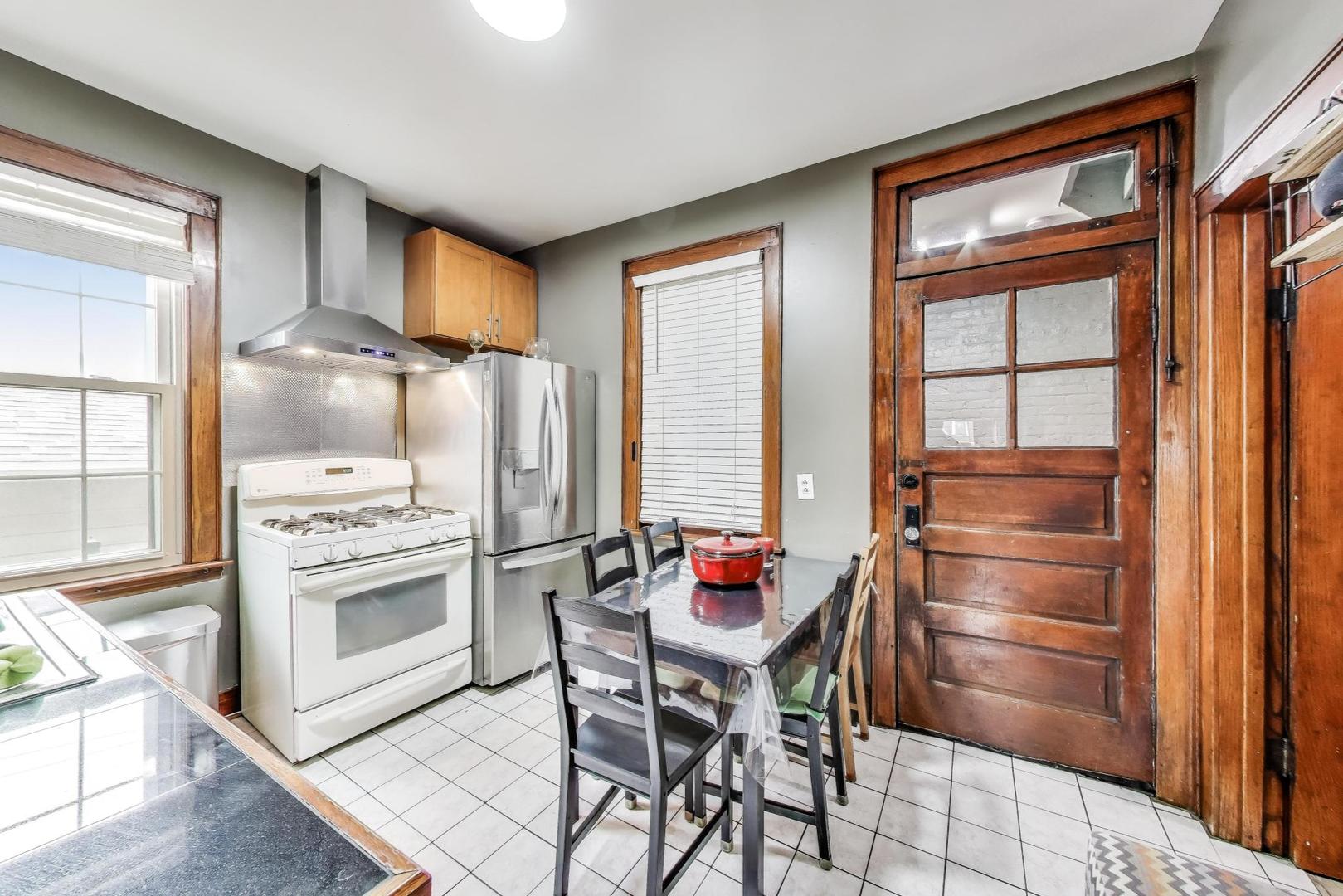 6432 South Kilpatrick Avenue Chicago, IL 60629 - Photo 9 of 36 a kitchen with granite countertop a refrigerator and white cabinets