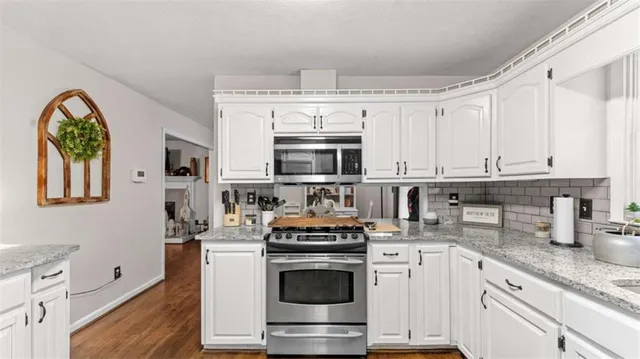 a kitchen with granite countertop a stove and a sink