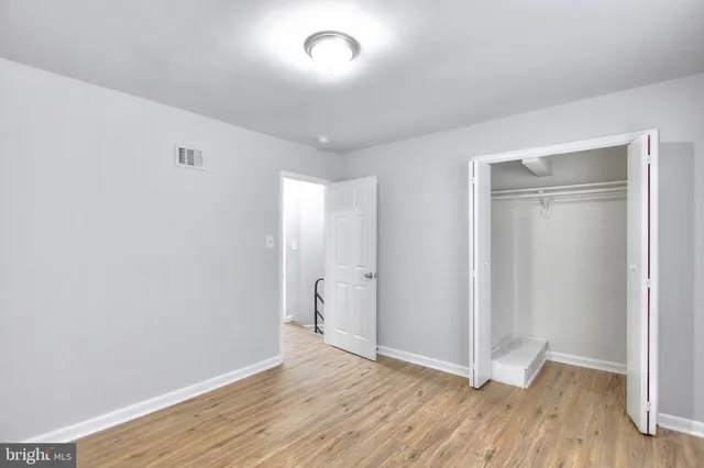 an empty room with wooden floor and closet