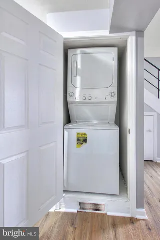 a utility room with wooden floor washer and dryer
