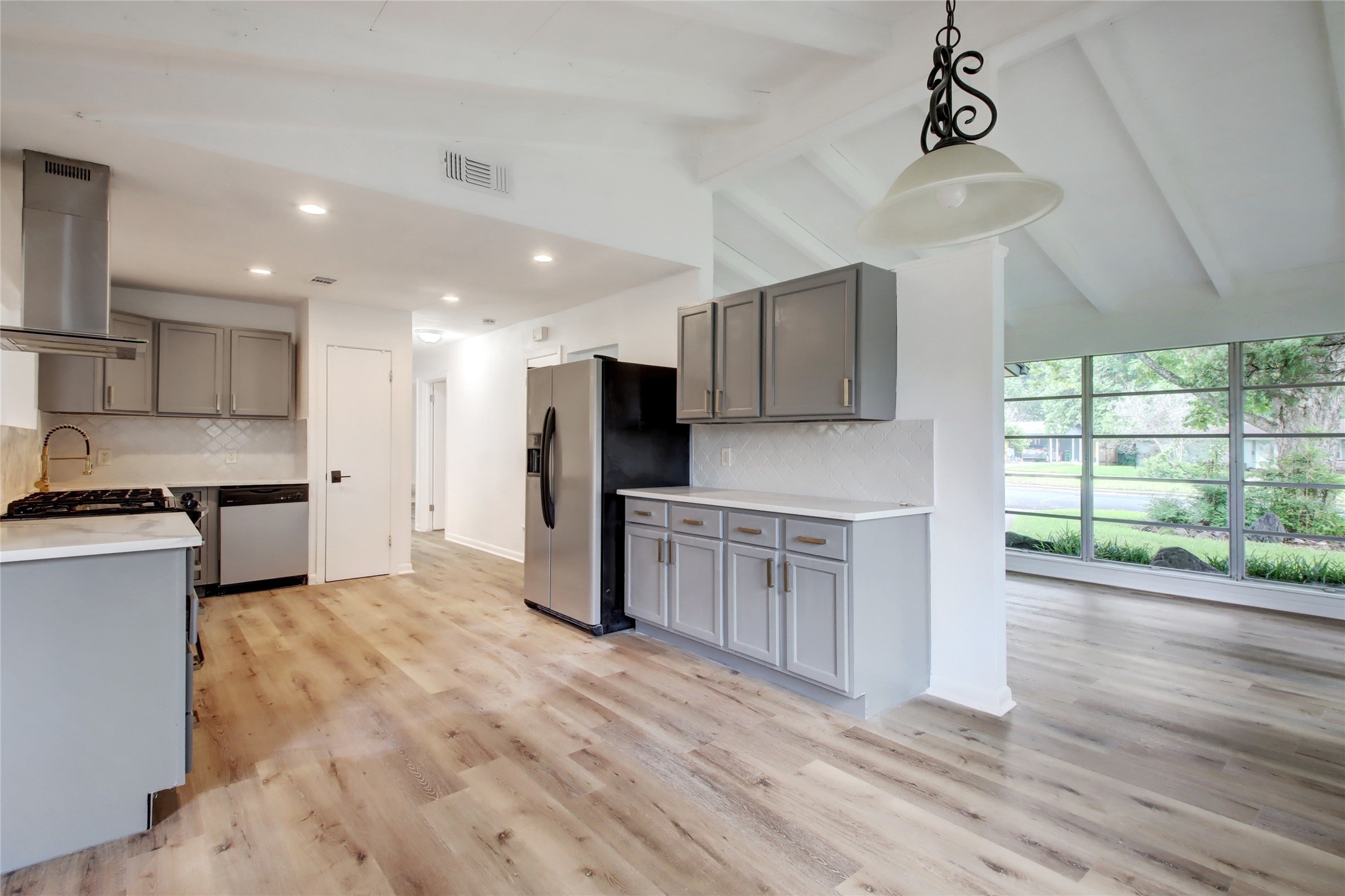 1906 Morrow Street Austin, TX 78757 - Photo 12 of 36 a large kitchen with stainless steel appliances kitchen island a large counter top and wooden floors