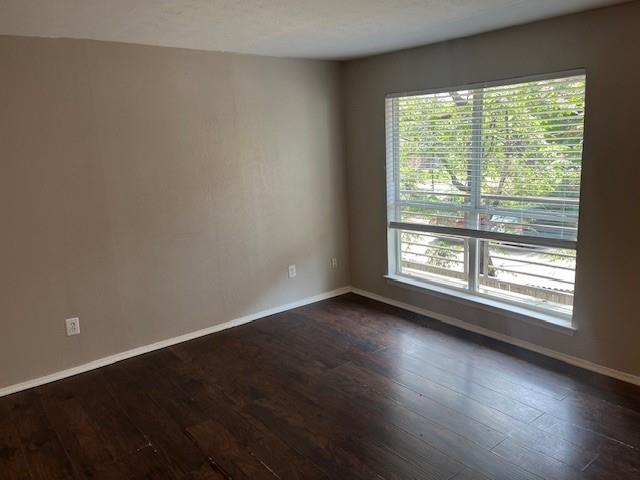 2821 Reagan Street, Unit 202 Dallas, TX 75219 - Photo 3 of 13 a view of an empty room with wooden floor and a window