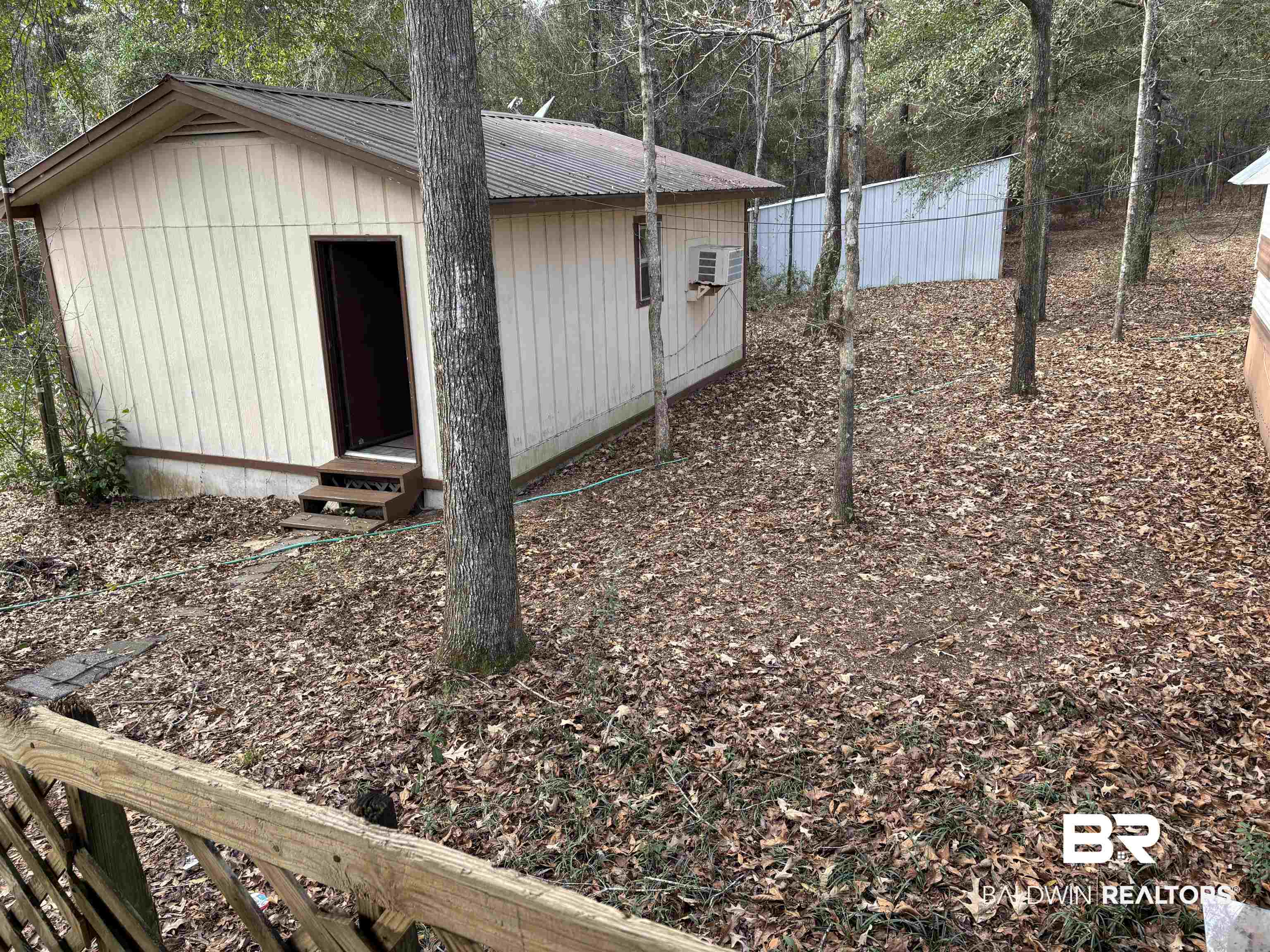 15575 Rogers Drive Chunchula, AL 36521 - Photo 21 of 42 View of outdoor structure featuring a wall unit AC, fence, and an outdoor structure