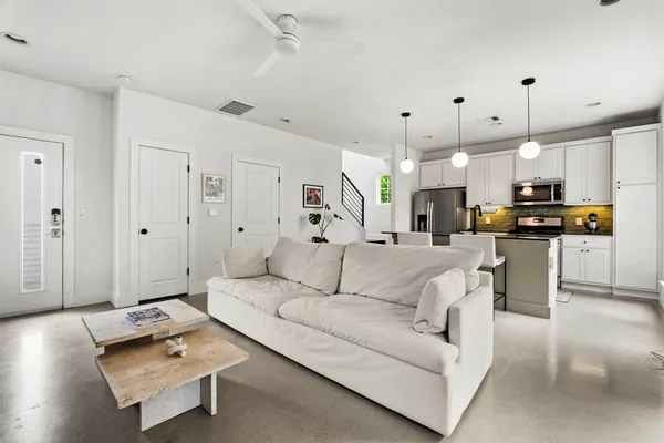 a living room with furniture and kitchen view