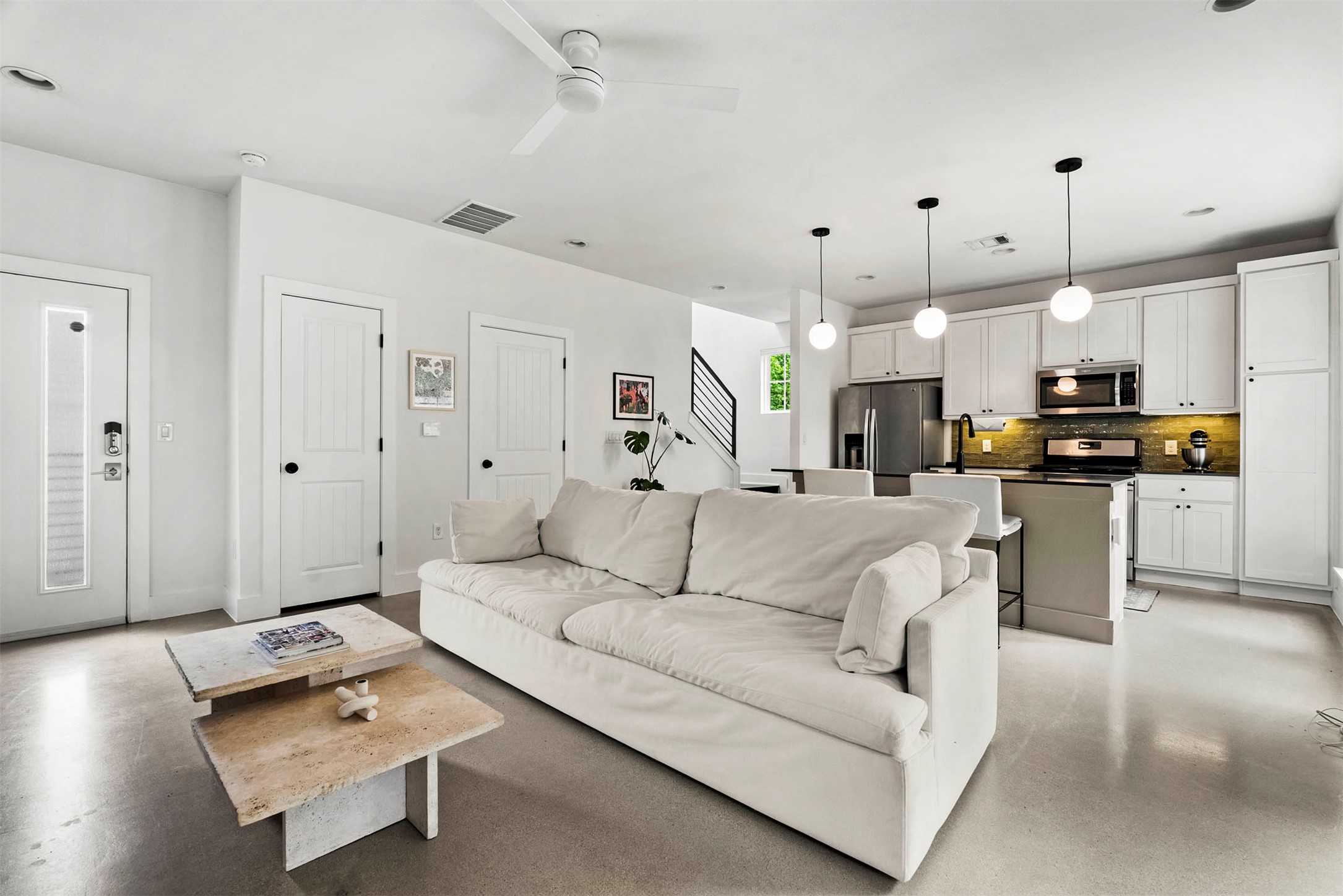 a living room with furniture and kitchen view
