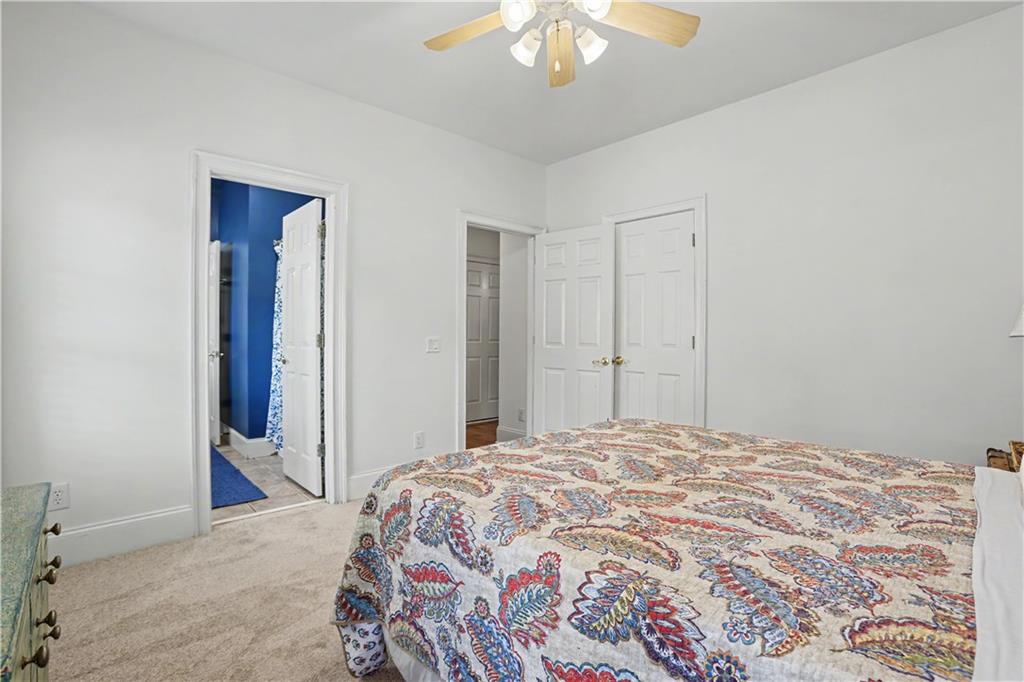 537 Old Collins Road Hoschton, GA 30548 - Photo 23 of 42 a bedroom with a bed and a chandelier