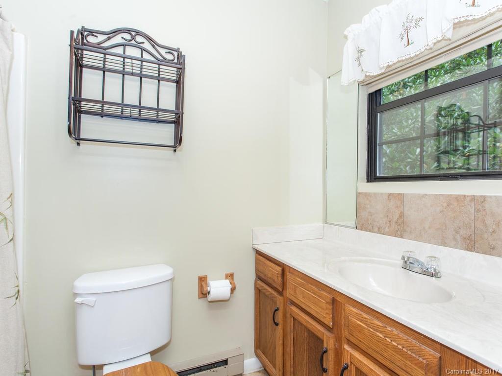 99 Apgar Road Candler, NC 28715 - Photo 13 of 20 a bathroom with a granite countertop sink mirror vanity and toilet