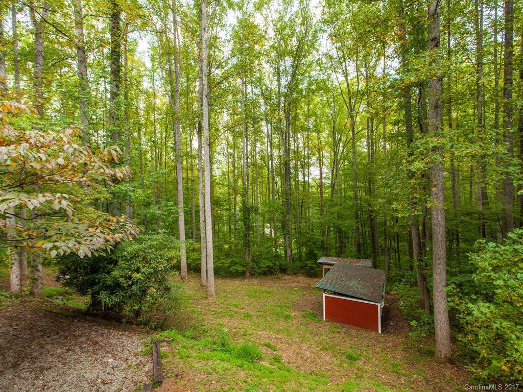 99 Apgar Road Candler, NC 28715 - Photo 19 of 20 a wooden bench sitting in the middle of a forest