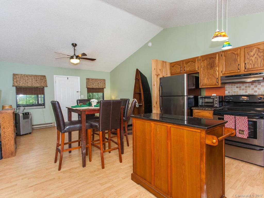 99 Apgar Road Candler, NC 28715 - Photo 8 of 20 a dining room with stainless steel appliances a table chairs and a refrigerator