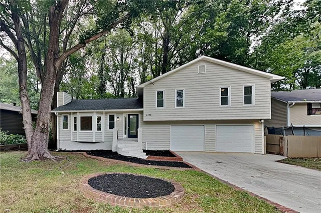 a front view of a house with a garden and yard
